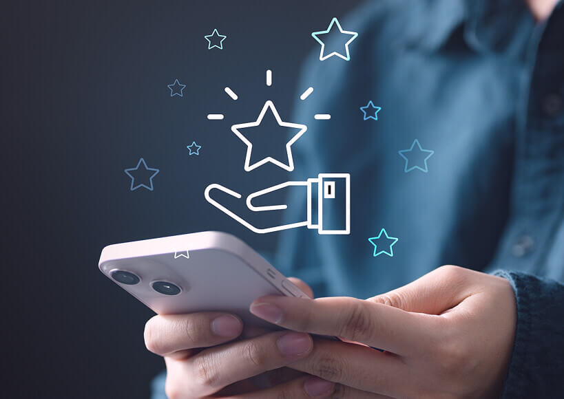 Closeup of a person’s torso. They are holding a cellphone and there is a drawing of a hand above it, palm up, holding a white star. Eight more stars are arrayed around it haphazardly.